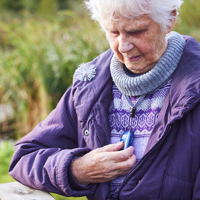 A woman pressing the button on an out-and-about personal alarm